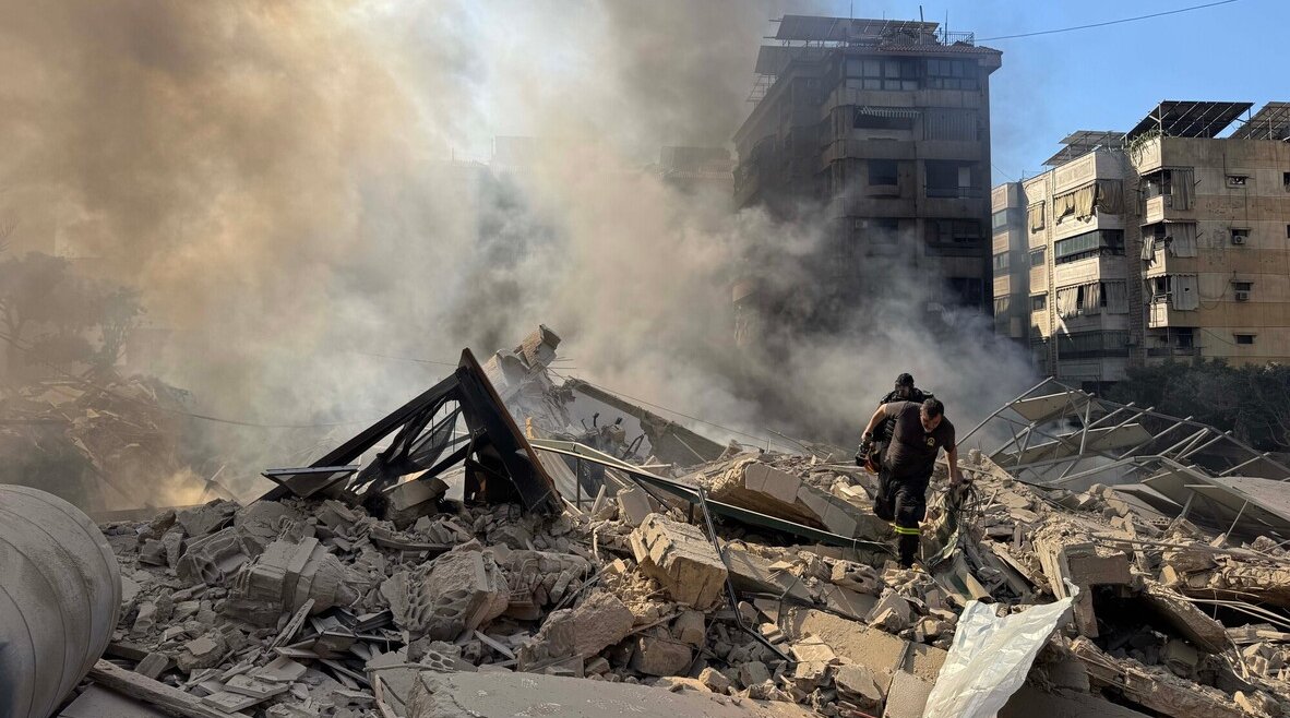 Rescue workers search through the rubble after Israel's overnight bombing of Beirut's southern suburbs.