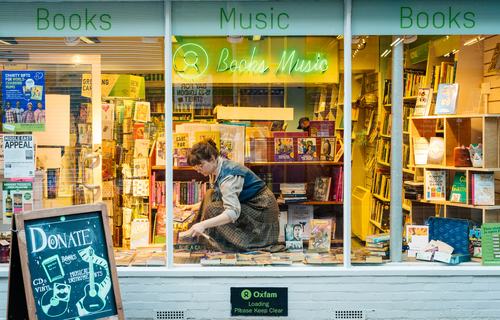 Volunteer Anna arranging the window display at Oxfam Shop Bedford Street, Norwich