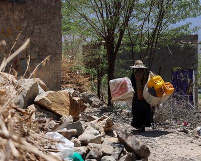 Women and children carrying water containers back to their homes