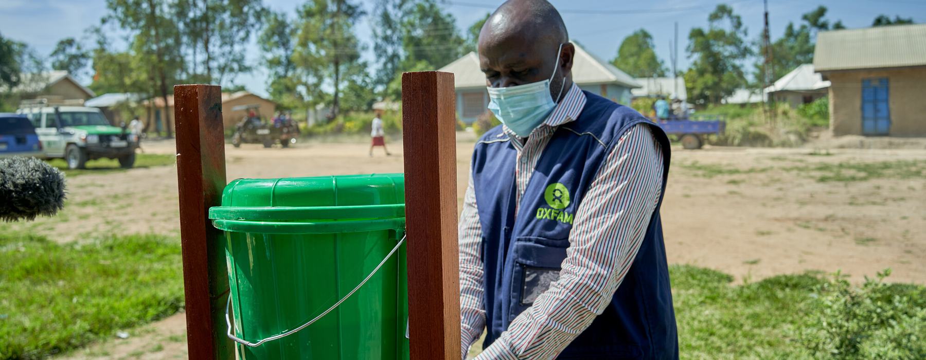 Oxfam health worker Roger uses a handwashing station in Rwampara in the Democratic Republic of the Congo.