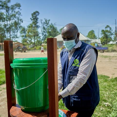 Oxfam health worker Roger uses a handwashing station in Rwampara in the Democratic Republic of the Congo.