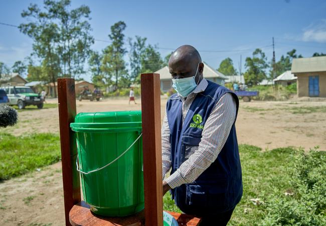 Oxfam health worker Roger uses a handwashing station in Rwampara in the Democratic Republic of the Congo.