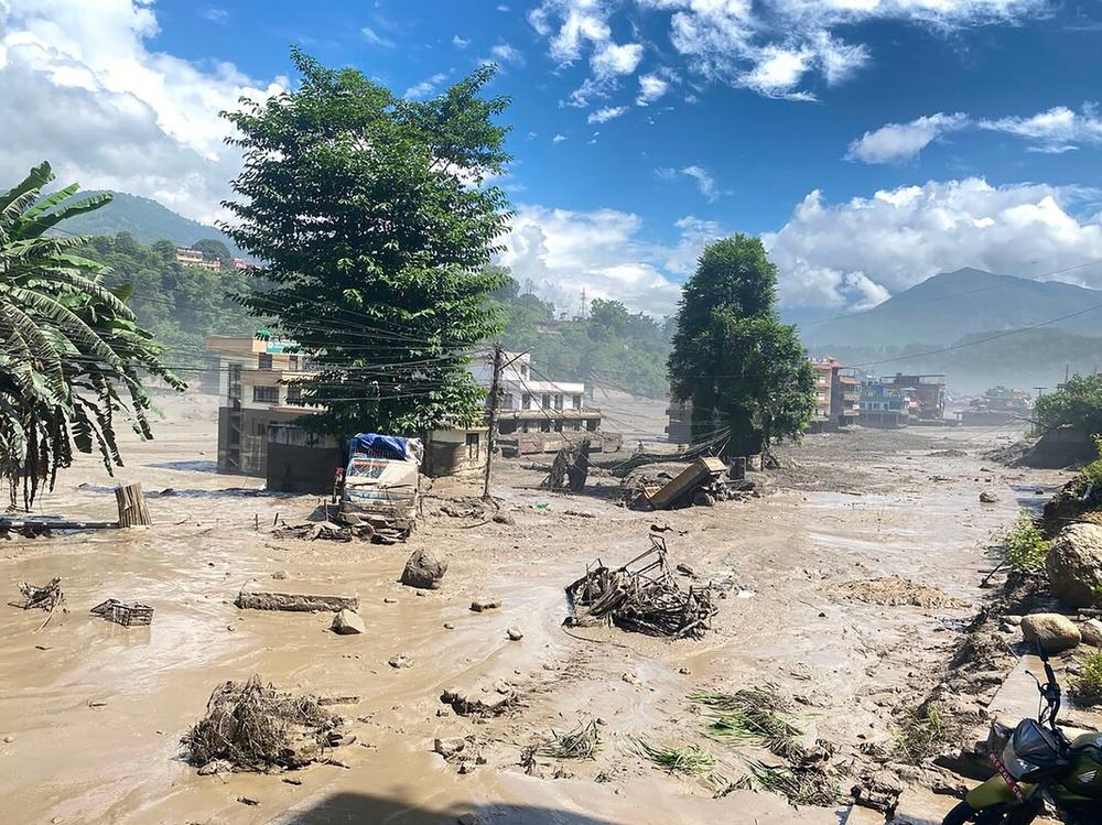 Buildings and trees surrounded by muddy flood water in Nuwakot District, Nepal after the huge flash flood.