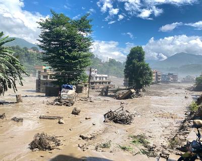 Buildings and trees surrounded by muddy flood water in Nuwakot District, Nepal after the huge flash flood.