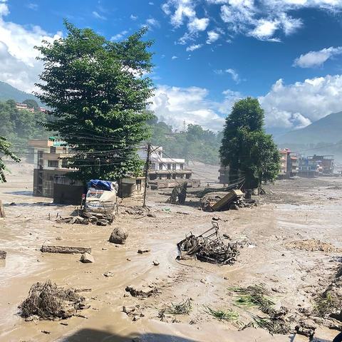 Buildings and trees surrounded by muddy flood water in Nuwakot District, Nepal after the huge flash flood.
