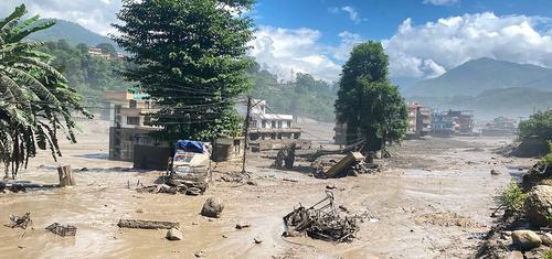 Buildings and trees surrounded by muddy flood water in Nuwakot District, Nepal after the huge flash flood.