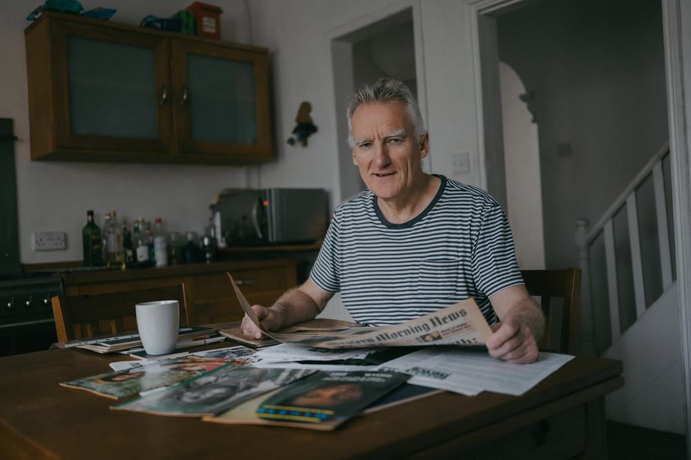 Phil looking over saved clippings of press releases he did for Oxfam.