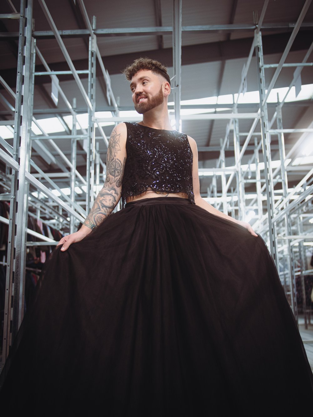 Conor 'The boy in the dress' at the oxfam warehouse at Milton point, wearing a sparkly black top, and a large maxi black tulle skirt