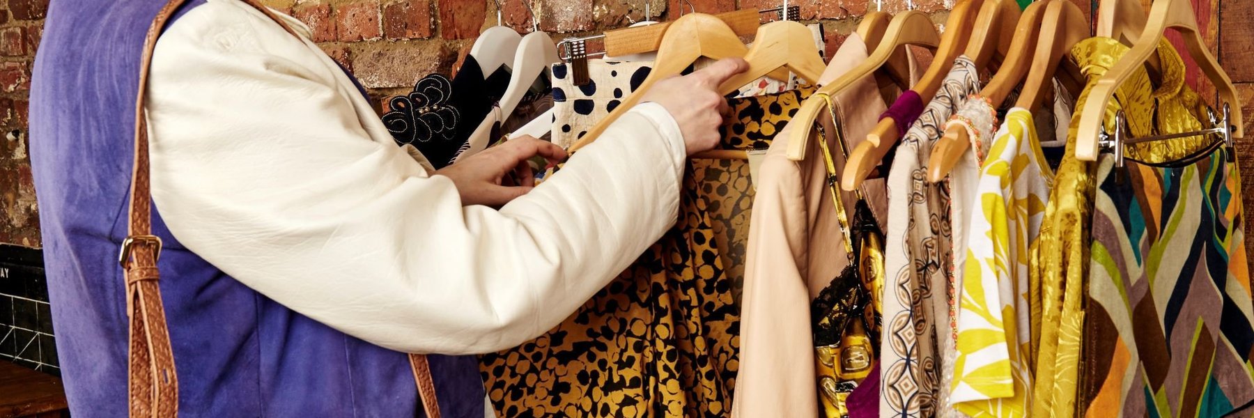 Person looking at clothes on a clothes rail