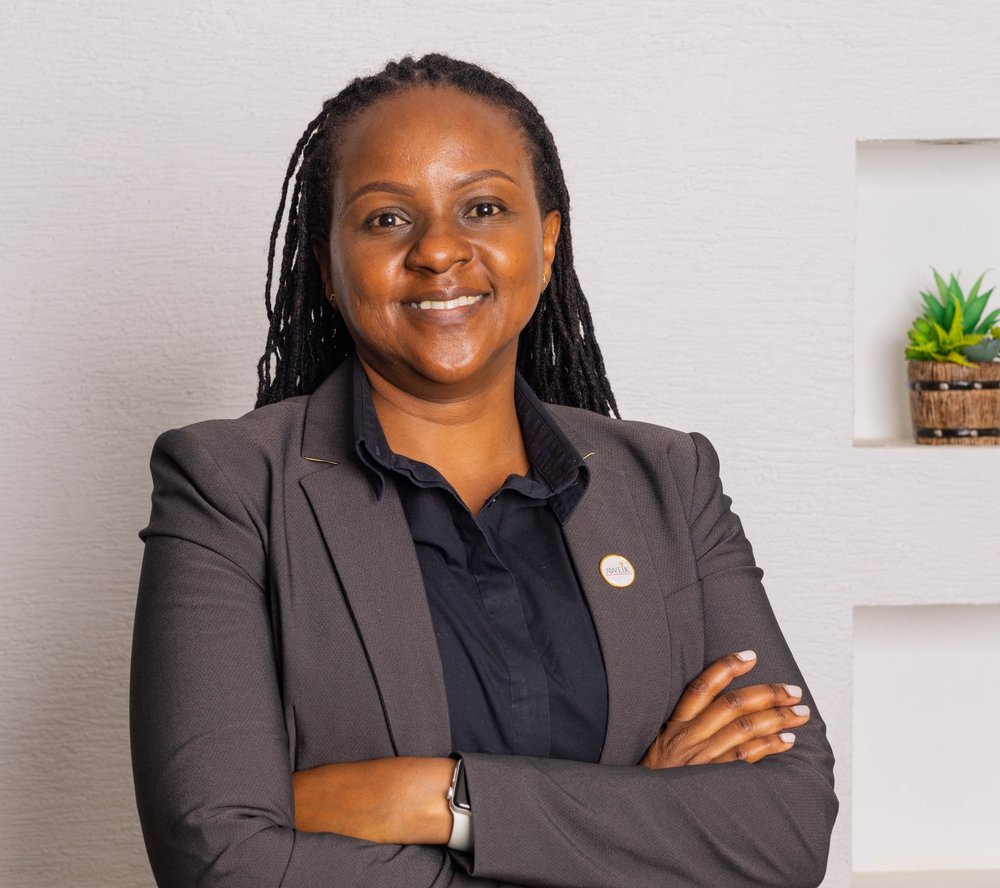 An image of Hanna Wang'ombe, a 40-year old Kenyan female CEO wearing a suit and smiling.