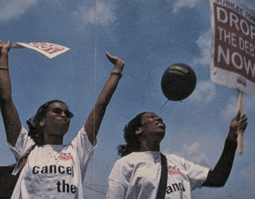 Protestors holding placards reading "Drop the debt now!"