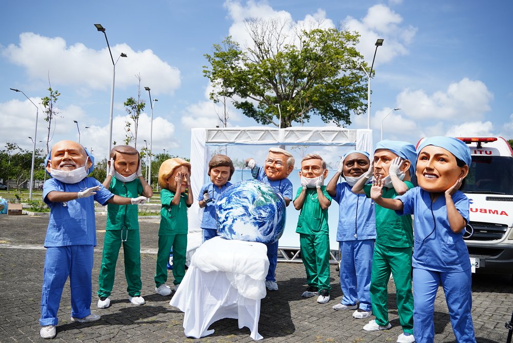 Activists dressed up in big heads that represent world leaders - all dressed as surgeons doing poor surgery on the planet.