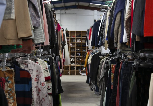 Rails of second hand clothing in Oxfam's Batley Warehouse