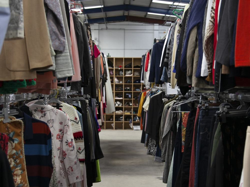 Rails of second hand clothing in Oxfam's Batley Warehouse