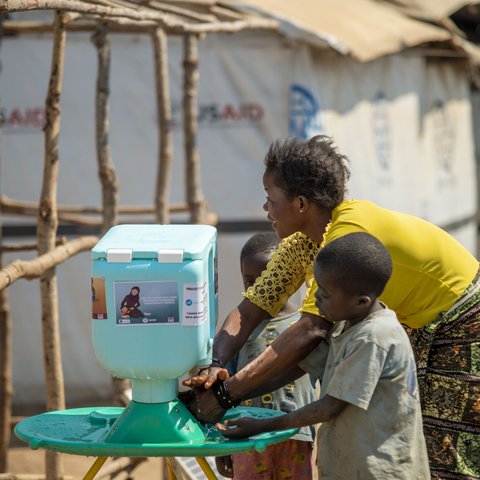 Lumbumba shows her young children how to use the new hand washing kit