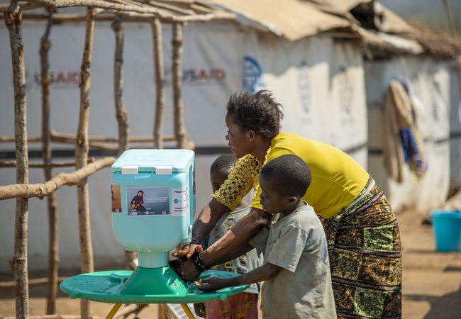 Lumbumba shows her young children how to use the new hand washing kit