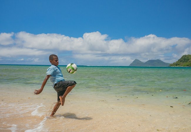 Sea-level rise: a boy in Vanuatu juggles a ball where there was once a playing field.