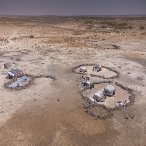 Some tent structures in the desert from above.