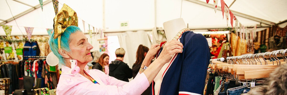 Oxfam shop volunteer dressing mannequin at Glastonbury