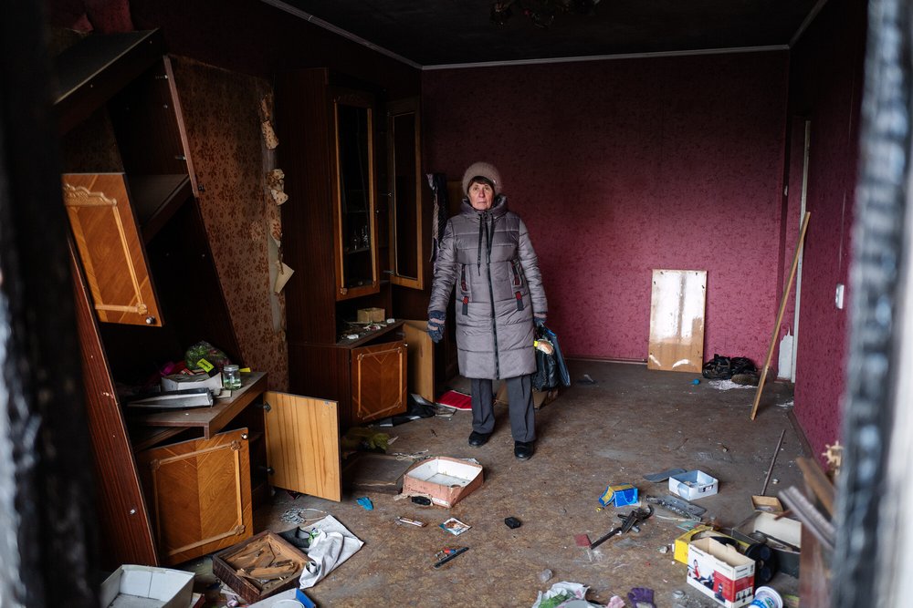 A woman standing in the remains of her home