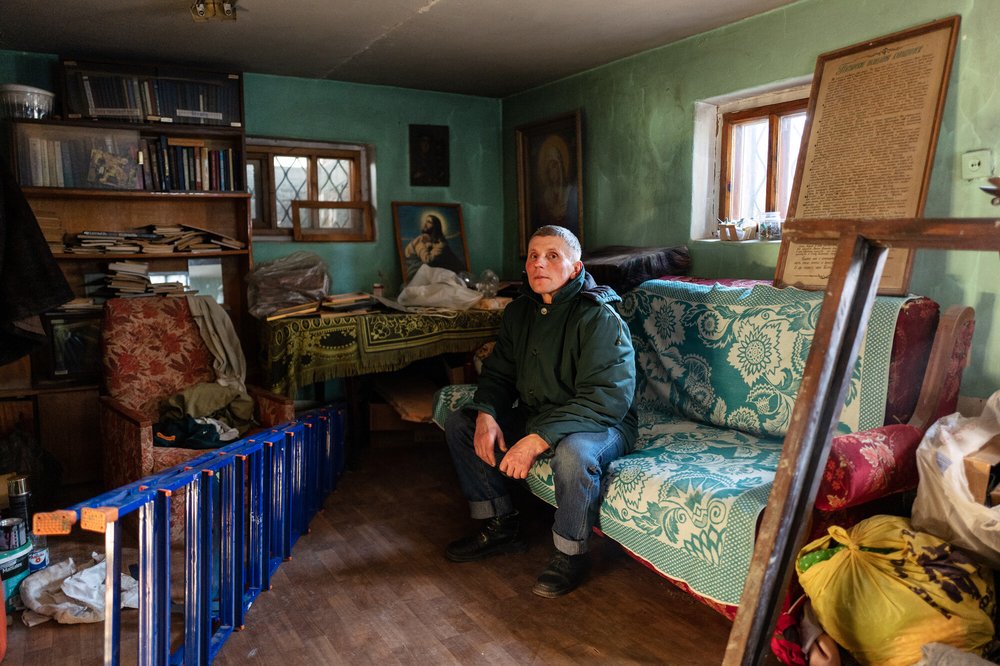 A man sitting in the basement of a church destroyed by the conflict