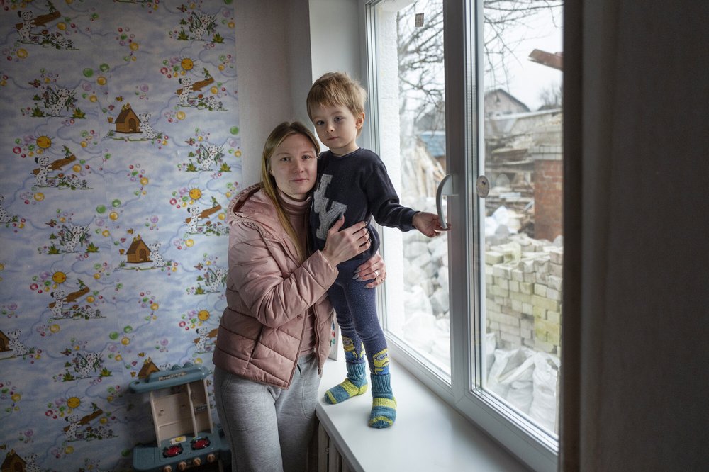 Mother and child stood by window. Image: Kieran Doherty / Oxfam