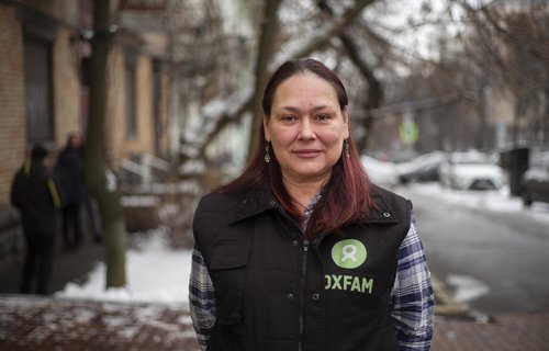 Gordana stands in an Oxfam jacket.