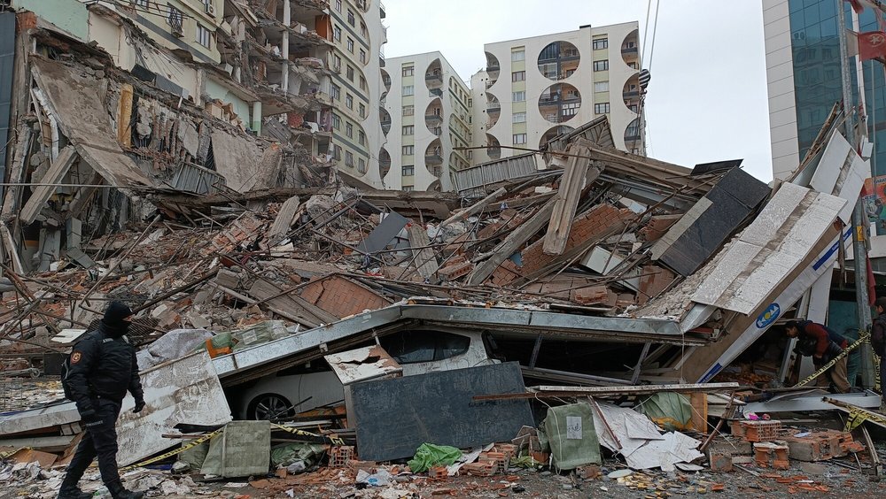 Aman walks past collapsed buildings at Galleria Apartment in Diyarbakir, southeast Turkey.