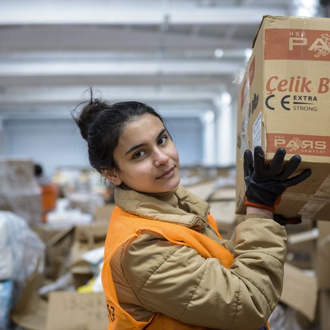 A young women handling boxes of donated items