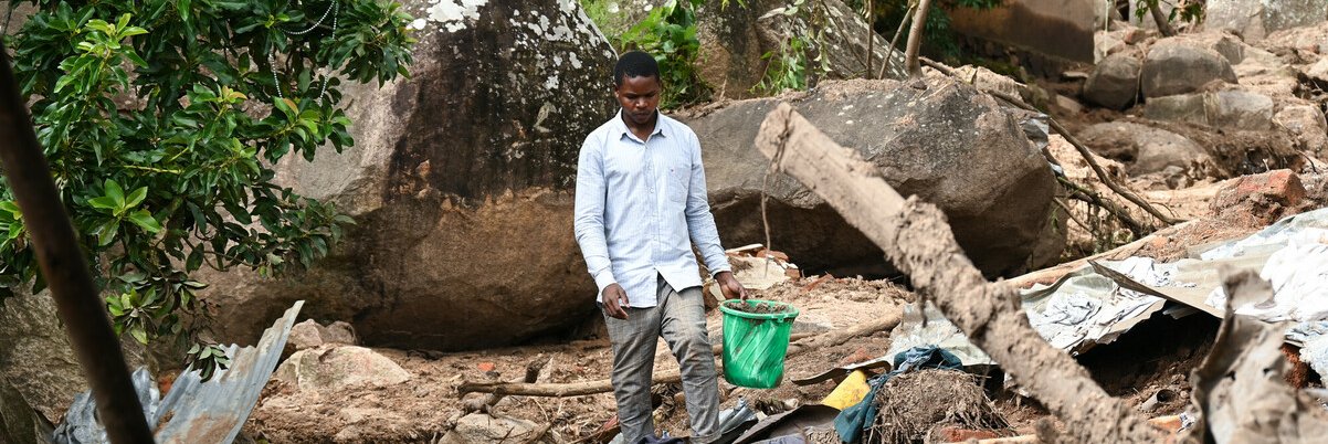 Evance Banda a survivor of Cyclone Freddy walks on the site of what used to be his family home in Blantyre, southern Malawi. Photo: Thoko Chikondi / Oxfam