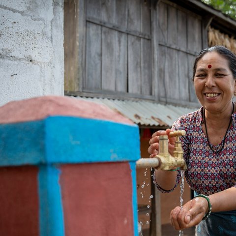 Pampha washing at her newly-installed tap at home in Dhading, Nepal.
