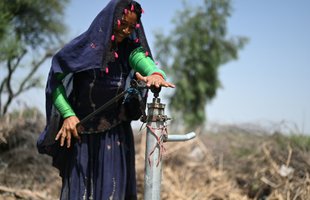 Samjho using the clean, safe water from the hand pump in her village in Sindh province, Pakistan.