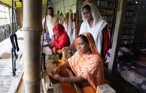 Nujhat (Entrepreneur, Talha Company Co-Founder) standing with Monjuara and Mahmuda who are working making rugs in Talha home factory in Rangpur.