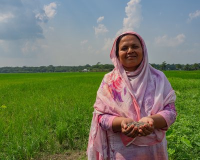 Dulu, a Bangladeshi woman in a pink hijab, smiles and looks at the camera.