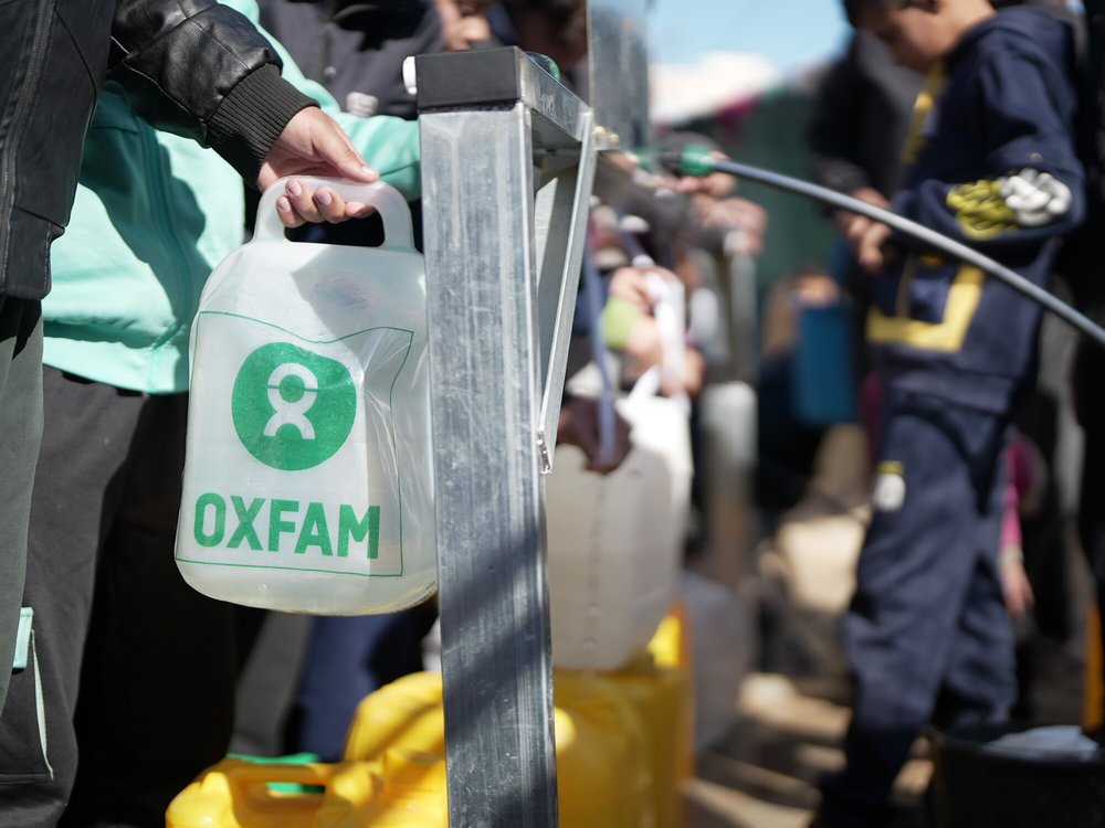 An Oxfam-branded water container being filled at a newly installed desalination unit in South Gaza.