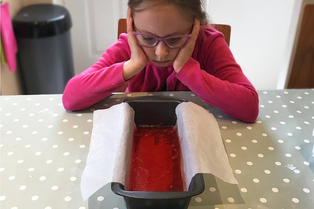 A child looks comically bored while waiting for homemade soap to set