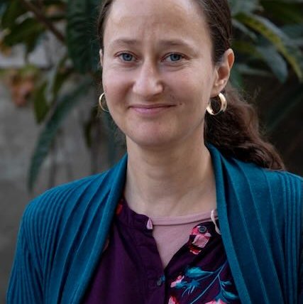 A woman standing against a green background