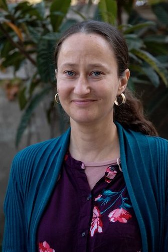 A woman standing against a green background