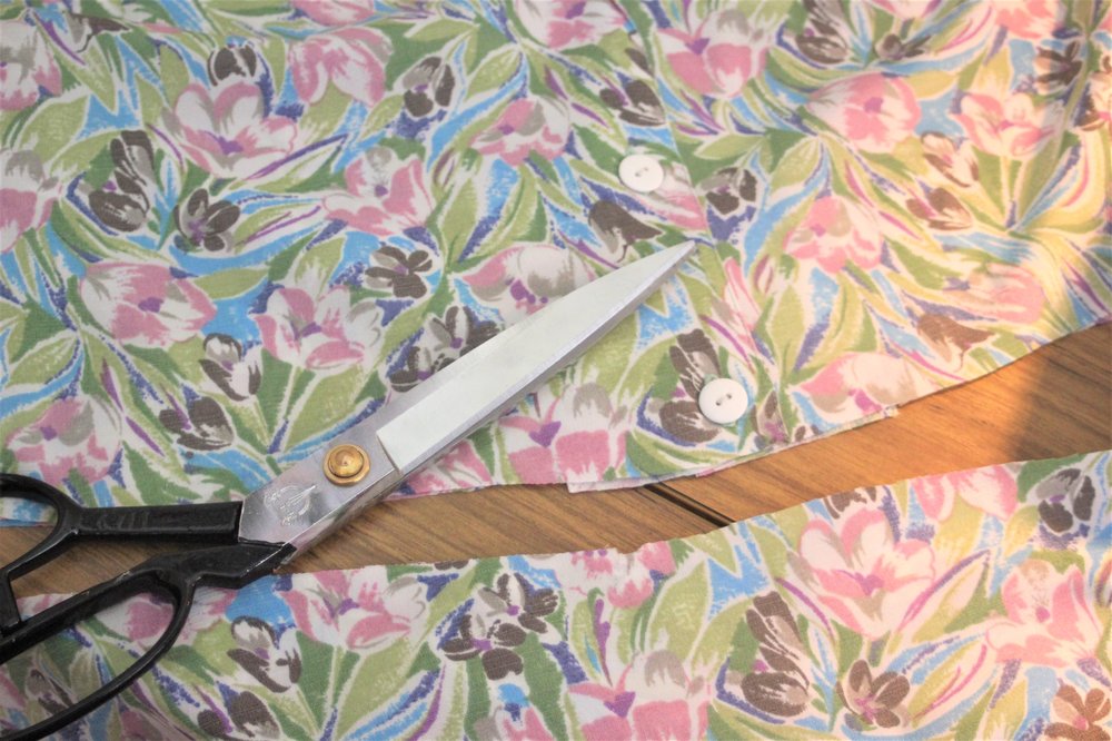 A piece of floral fabric being cut with scissors. Photo: Cassie Fairy