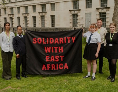 Amario and Mia, Send My Friend to School students, holding 'Solidarity with East Africa' banner alongside Oxfam staff before petition hand in at Number Ten Downing Street.