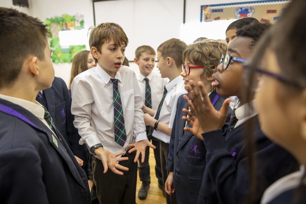 A group of school children taking part in a classroom discussion.