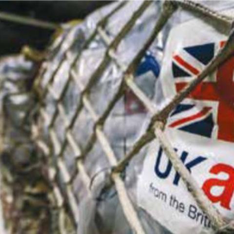 Pallets of supplies being loaded, each labelled 'UK aid'.