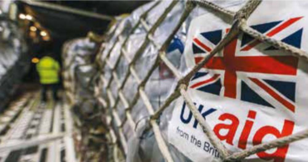Pallets of supplies being loaded, each labelled 'UK aid'.