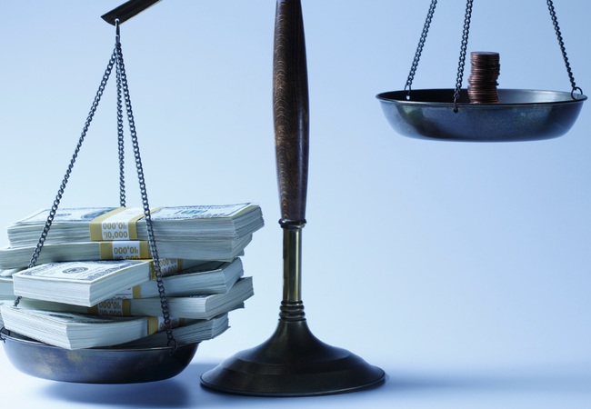 Set of scales with heavy bank notes on the left and small stack of light coins on the right.