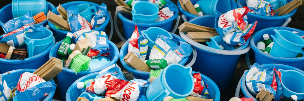 Lots of blue buckets, each filled with washing kits