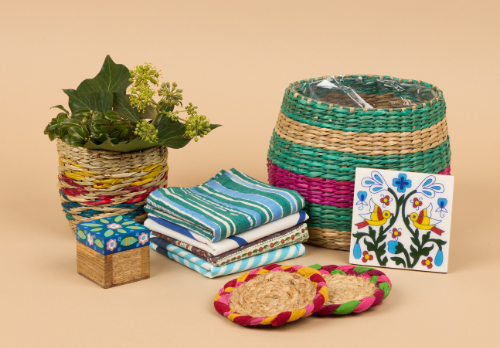 A gift bundle from Sourced by Oxfam, includes a colourful wicker plant pot, coasters, striped napkins and a floral trinket pot.