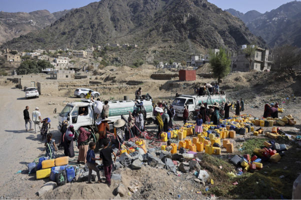Families gather around charity water trucks filling jerrycans to survive the ongoing water crisis. Taiz Governorate.