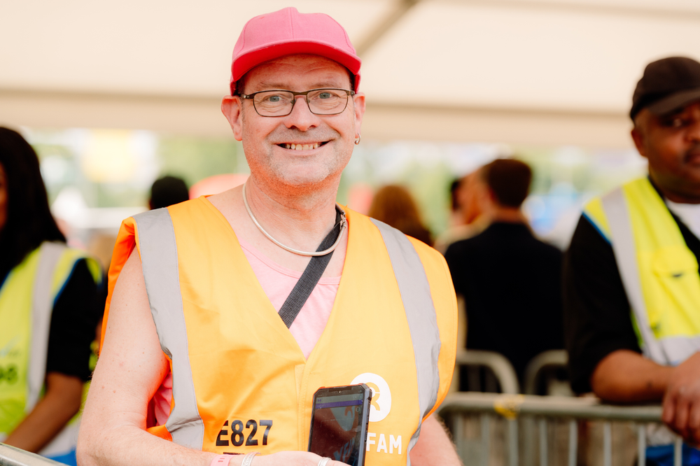 Oxfam festival volunteer working on a gate and smiling