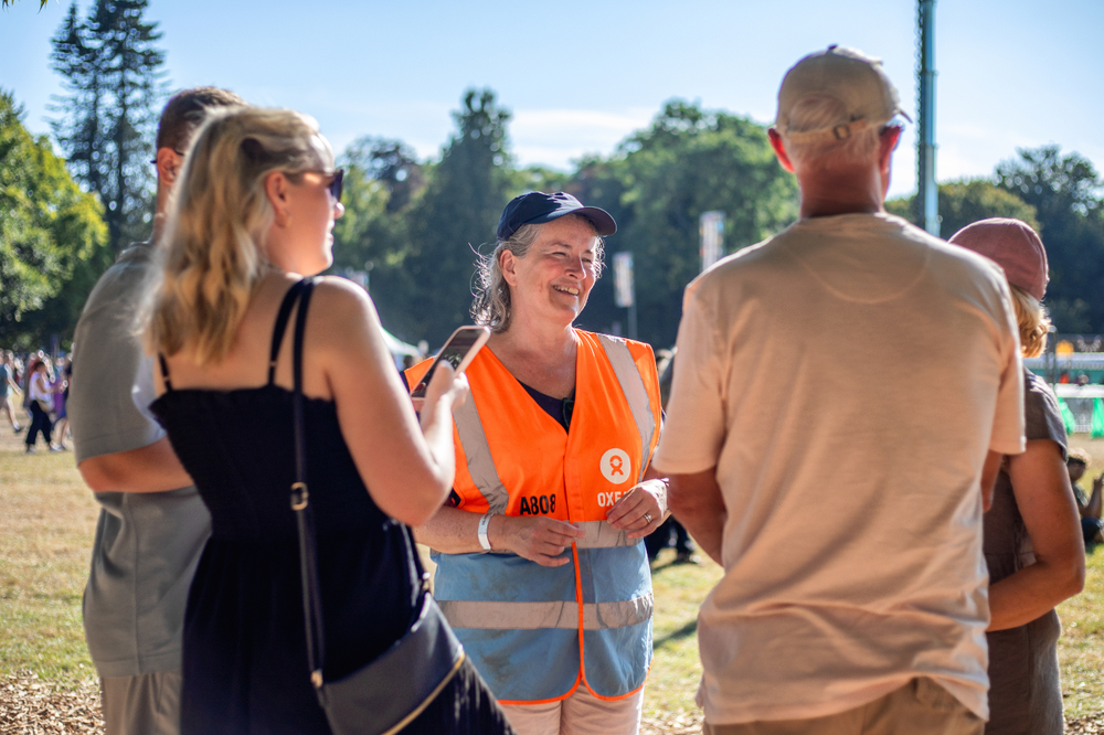 Oxfam festival steward speaking with a group of festivalgoers