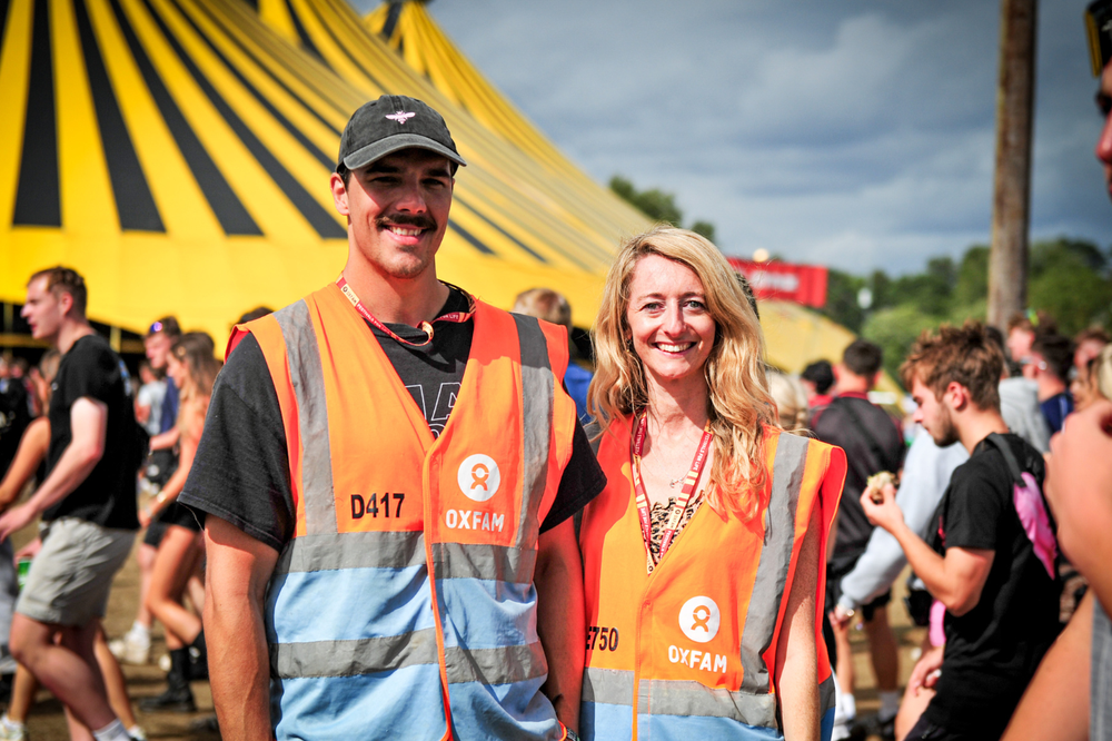 Two Oxfam Festival volunteers standing outside a festival venue
